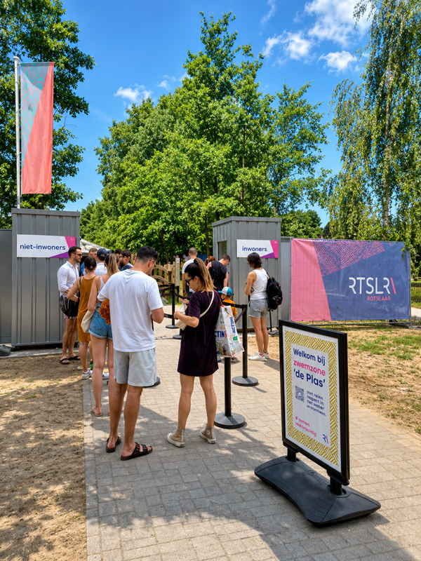 Entrance to De Plas beach in Rotselaar with visitors queuing to access the supervised swimming area