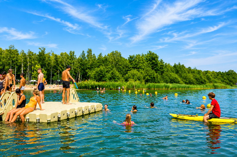 Floating pontoon at De Plas beach in Rotselaar with swimmers and a lifeguard ensuring the safety of the swimming area