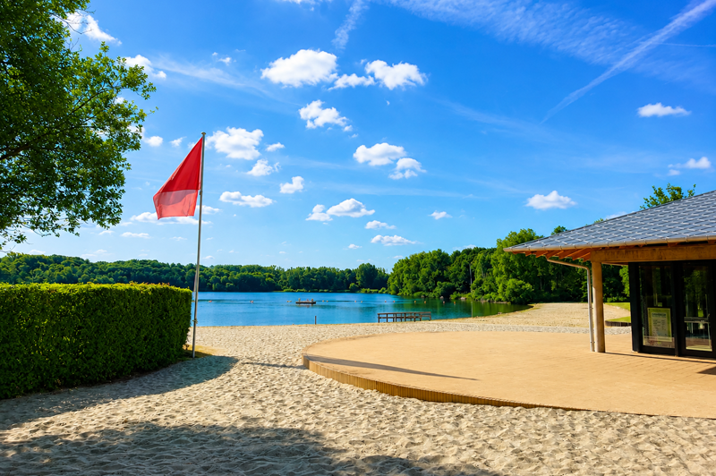 General view of De Plas beach in Rotselaar featuring the beach pavilion, sandy shoreline, and lake