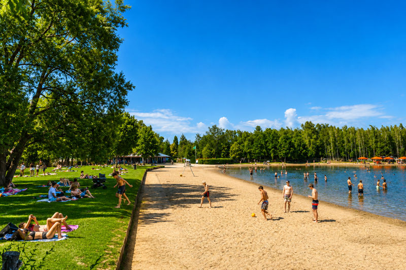 Jeunes profitant de la baignade dans le lac de la plage de De Plas à Rotselaar autour du ponton flottant