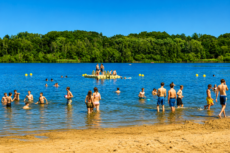 Plage de De Plas à Rotselaar animée par de nombreux baigneurs profitant du lac lors d'une journée ensoleillée